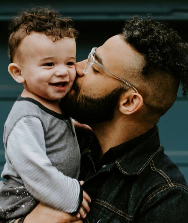 A man kissing his young boy